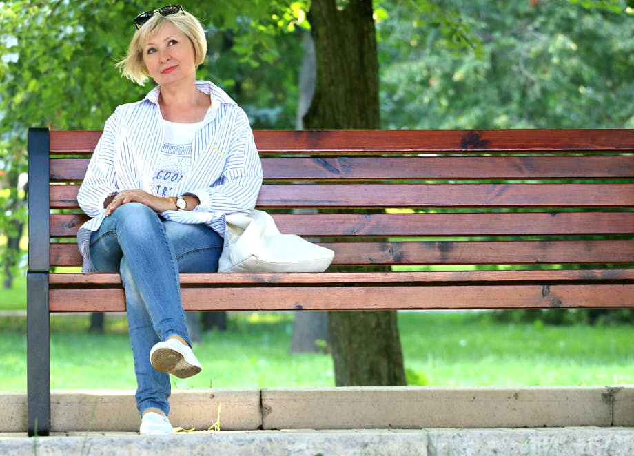 woman sitting on a bench alone representing that we need face-to-face interaction, not isolation and doubt.