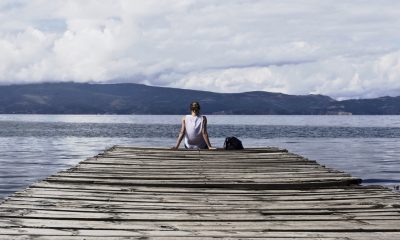 Person at the end of a dock representing self-care and alone time.