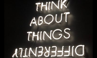 Neon sign saying "think about things differently" regarding the ideal worker.