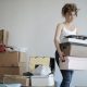 Woman carrying boxes representing minimizing clutter.