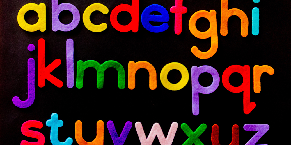 Bright colored alphabet on dark background, a starting place for branding and naming a company.