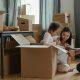 family in their living room with moving boxes during the competitive housing market