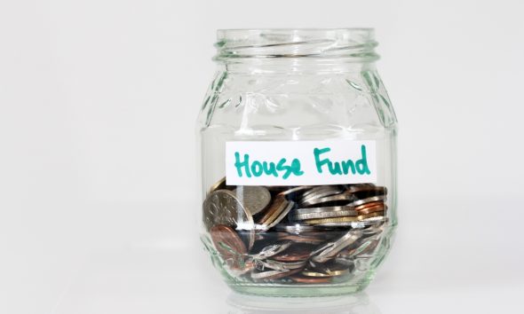 Glass jar of coins labeled House Fund.