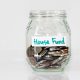 Glass jar of coins labeled House Fund.