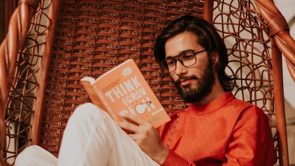 Man reading book called _think and grow_ during free time