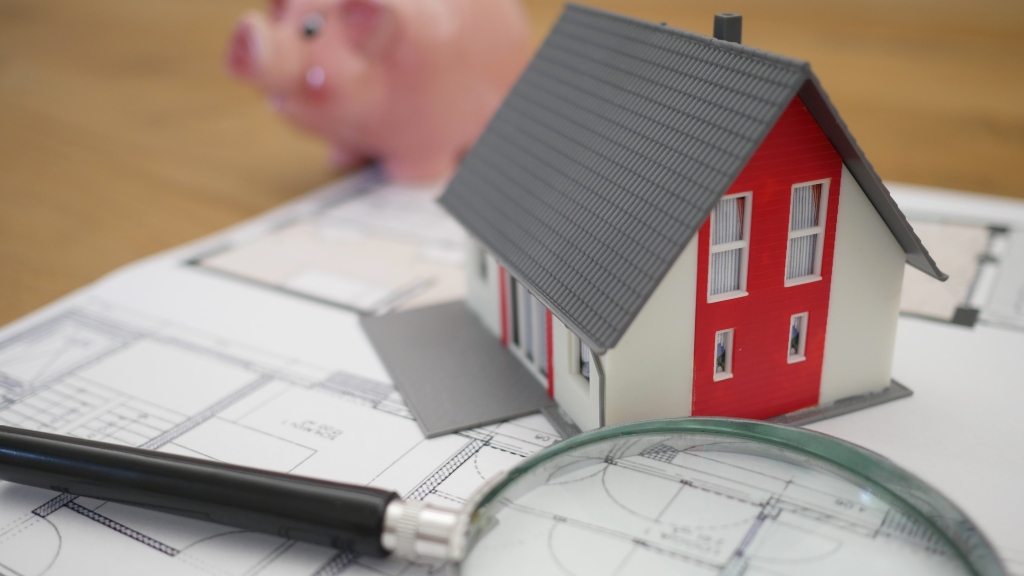 magnifying glass, piggy bank, and credit paperwork representing home buying