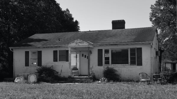older home in black and white representing small town america being ruined by Airbnb