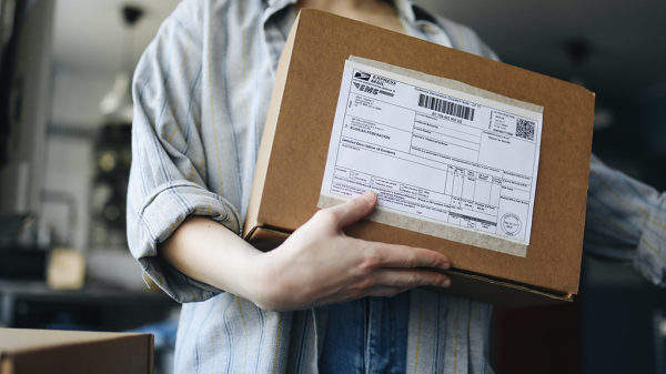 A person holds a package from the UPS mail service.