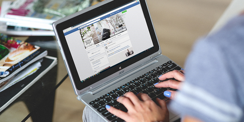 Laptop on lap open to Facebook/Metaverse page representing ad targeting.