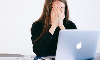 Woman stressed over laptop while working from home.