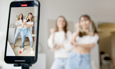 Influencer taking video on a smart phone to record dances.