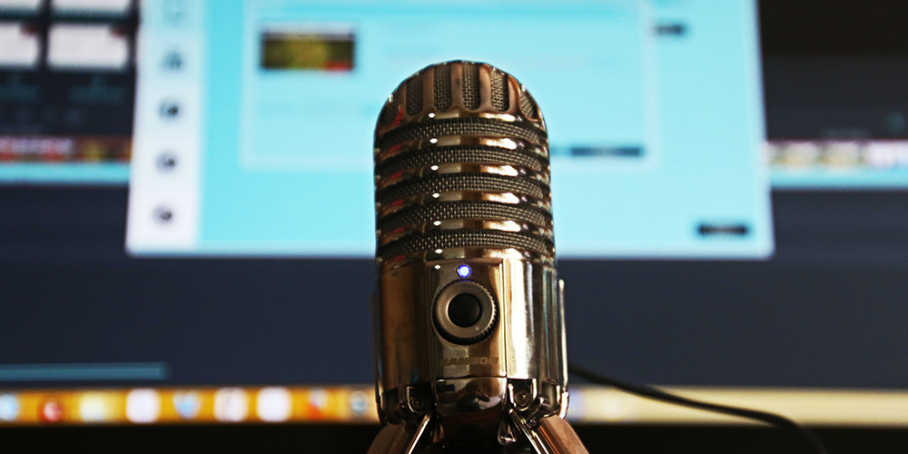 Podcasting mic in front of a computer recording a podcast