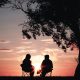Two silhouettes of people looking out over the sunset to discuss succession planning.