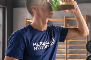 Man drinking Herbalife shake and wearing MLM shirt.