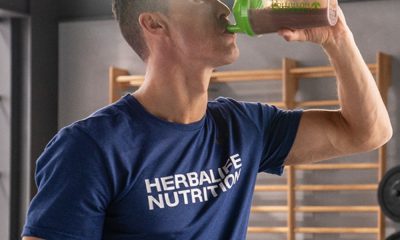 Man drinking Herbalife shake and wearing MLM shirt.