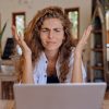 Woman confused at computer representing small business owner's being hacked at Meta.
