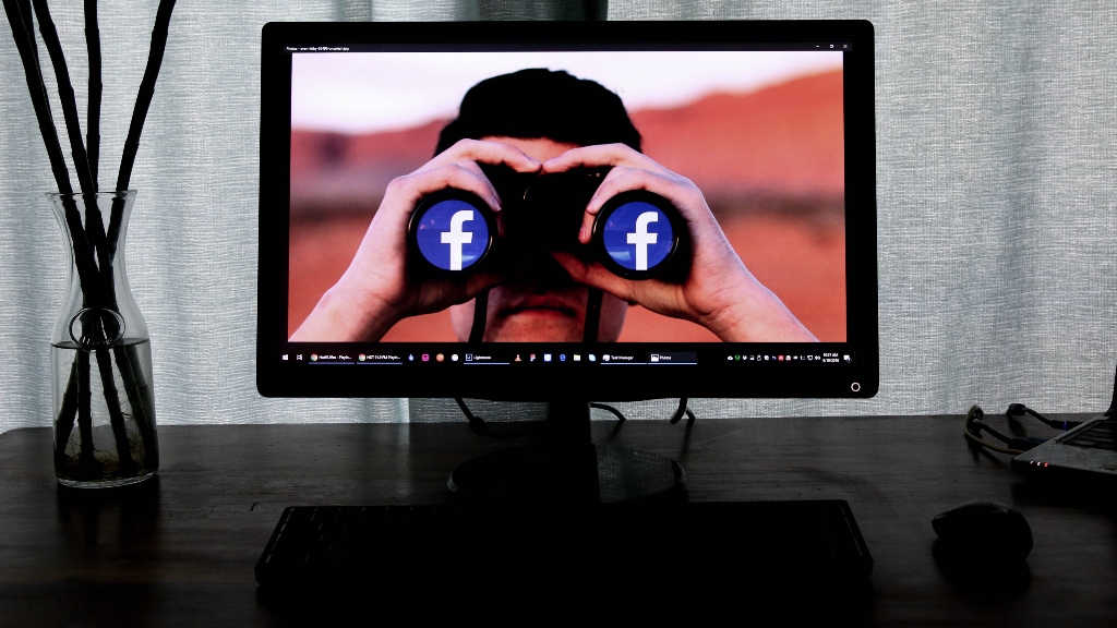 Facebook (Meta) in binoculars on computer representing oversight board policies