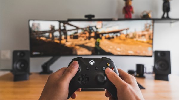 person holding xbox control representing video games