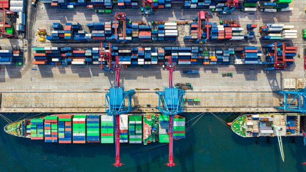 A bird's eye view of a ship docking at a port where the supply chain can be managed.
